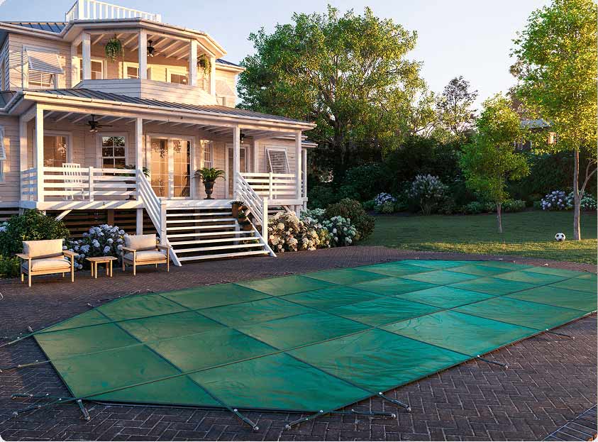 green seasonal safety cover on inground pool in New England type backyard