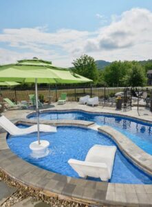 Fiberglass pool with mosaic tile design featuring a tanning ledge