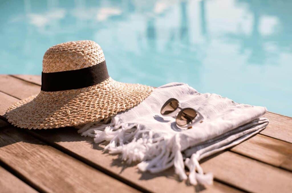 poolside hat, towel and sunglassess