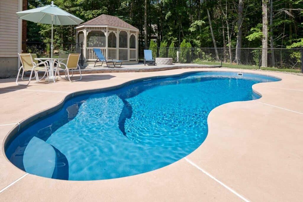 Freeform fiberglass plunge pool with wide steps, umbrella, and gazebo