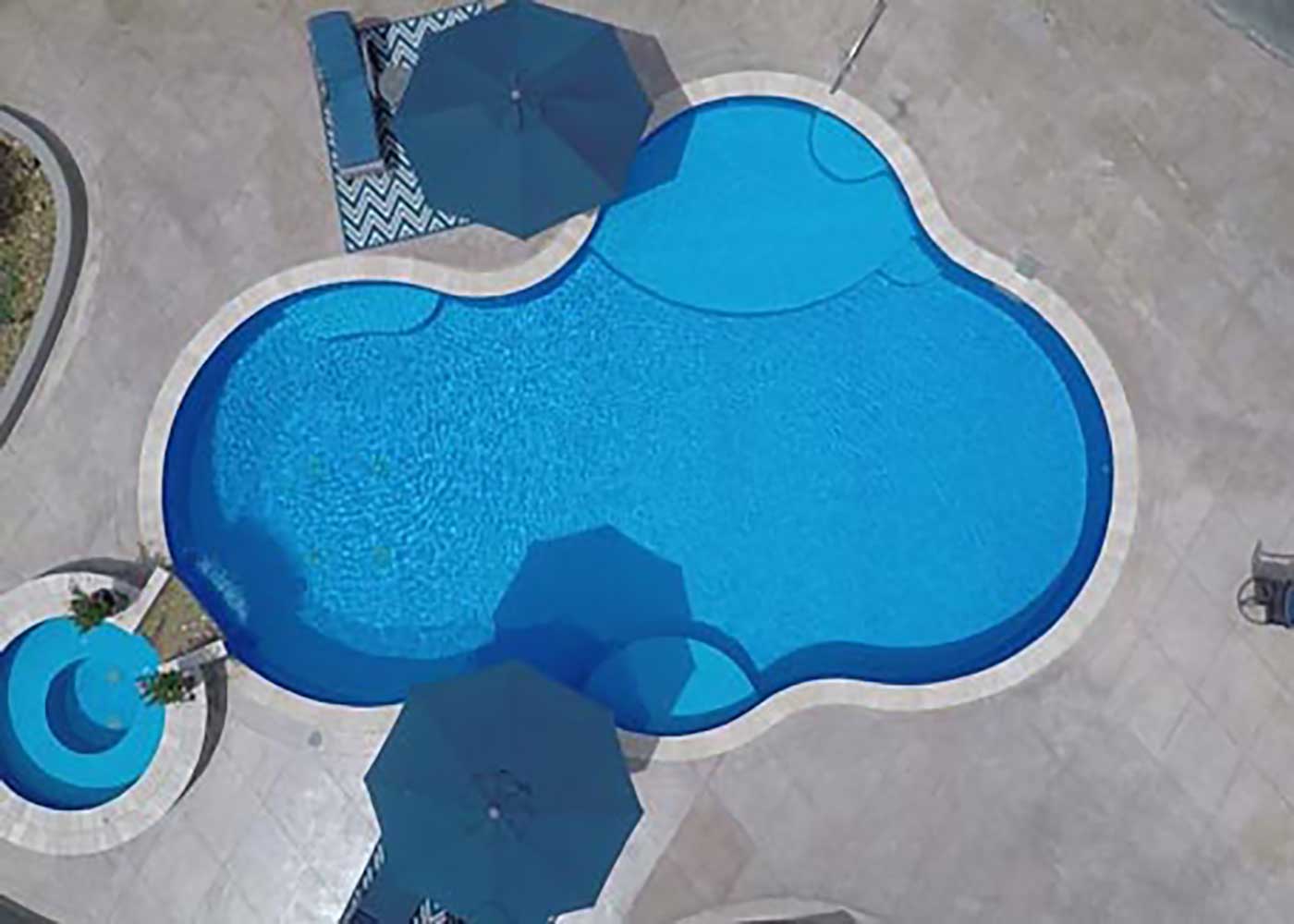 Aerial view of a large freeform vinyl liner inground pool, showcasing the vibrant blue liner pattern.